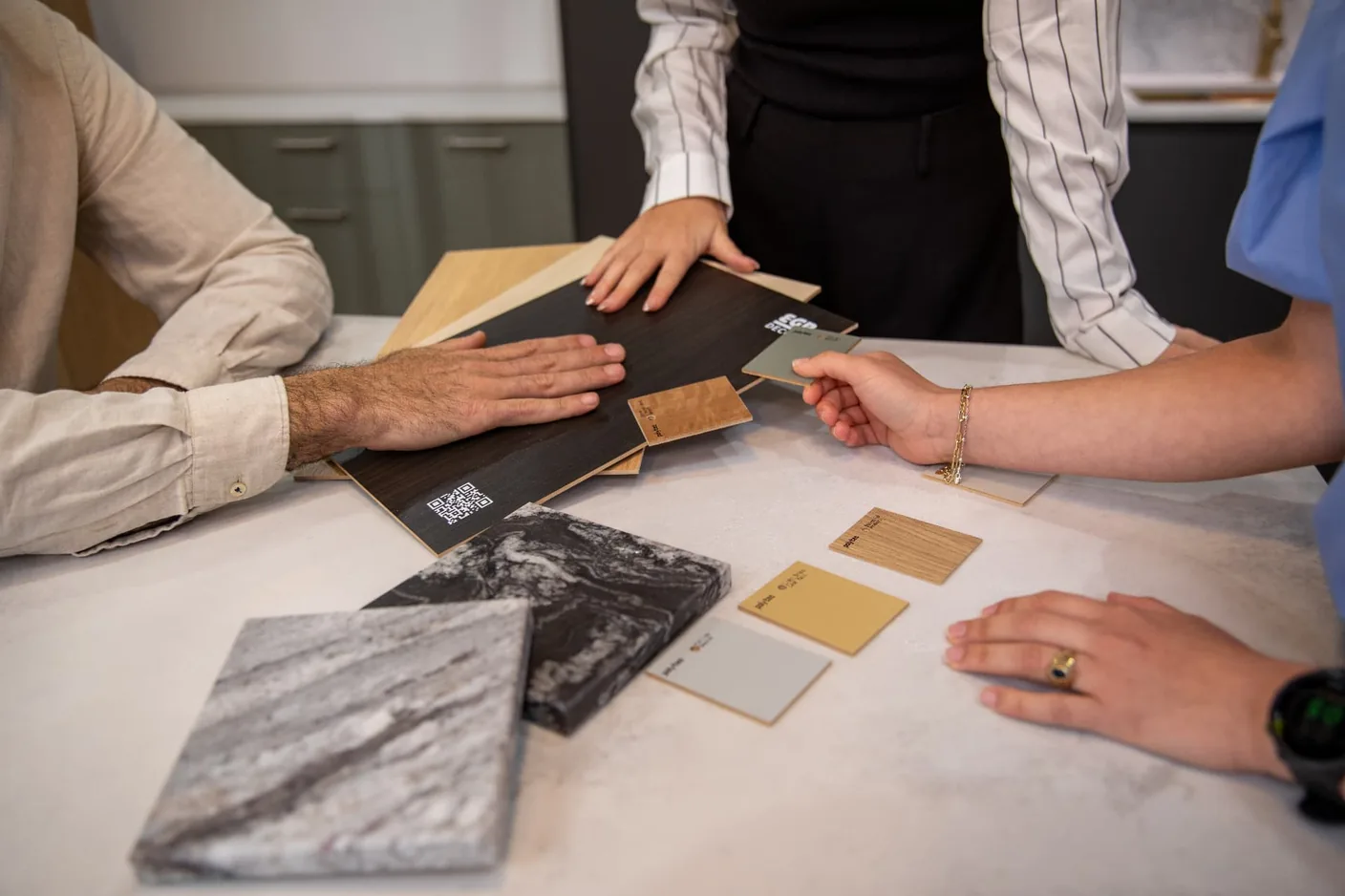 A Haute Kitchens designer reviewing material samples and finishes with clients during a consultation
